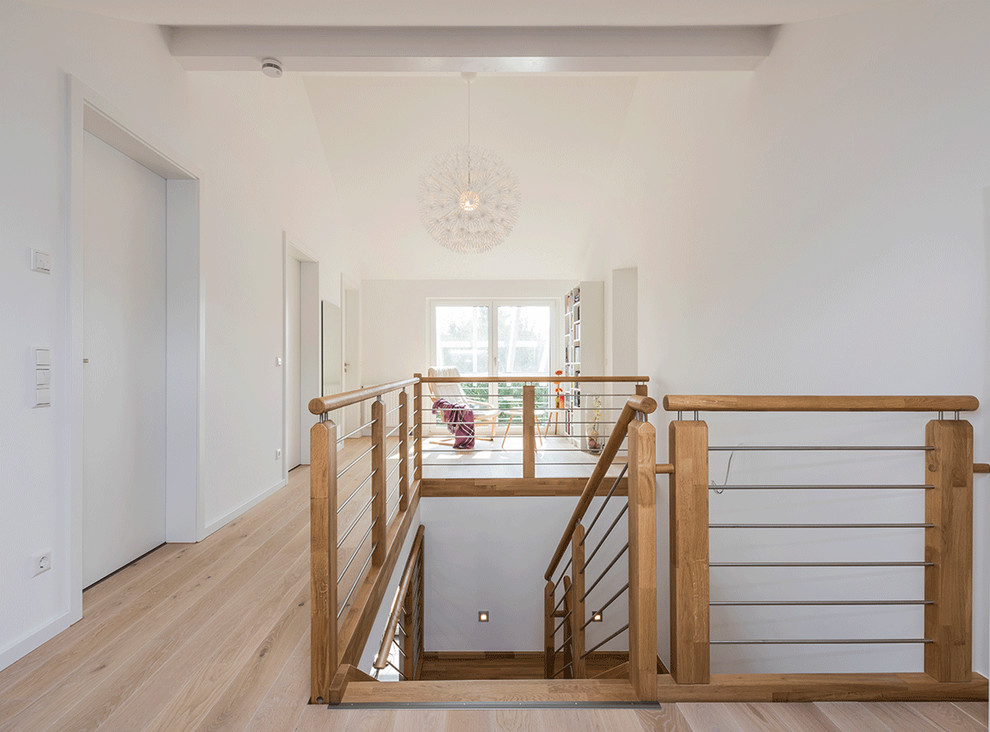 Idéer för en stor skandinavisk hall, med vita väggar, ljust trägolv och brunt golv