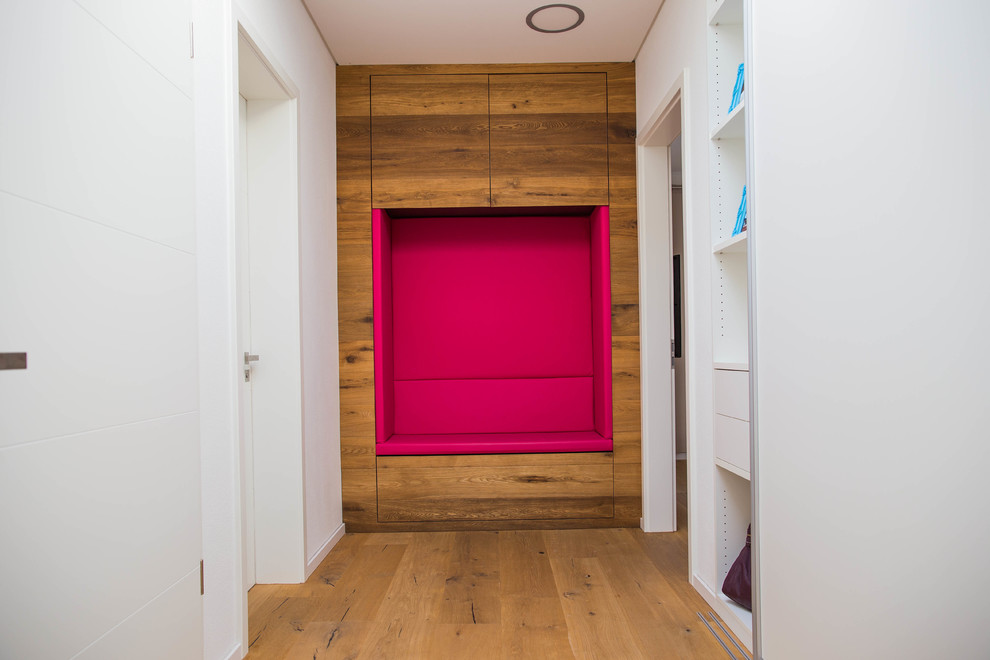 Immagine di un ingresso o corridoio minimal di medie dimensioni con pareti bianche, pavimento in legno massello medio e pavimento marrone