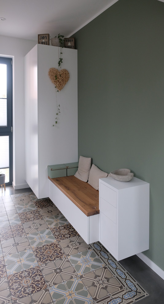 На фото: коридор среднего размера в современном стиле с зелеными стенами и полом из керамической плитки с