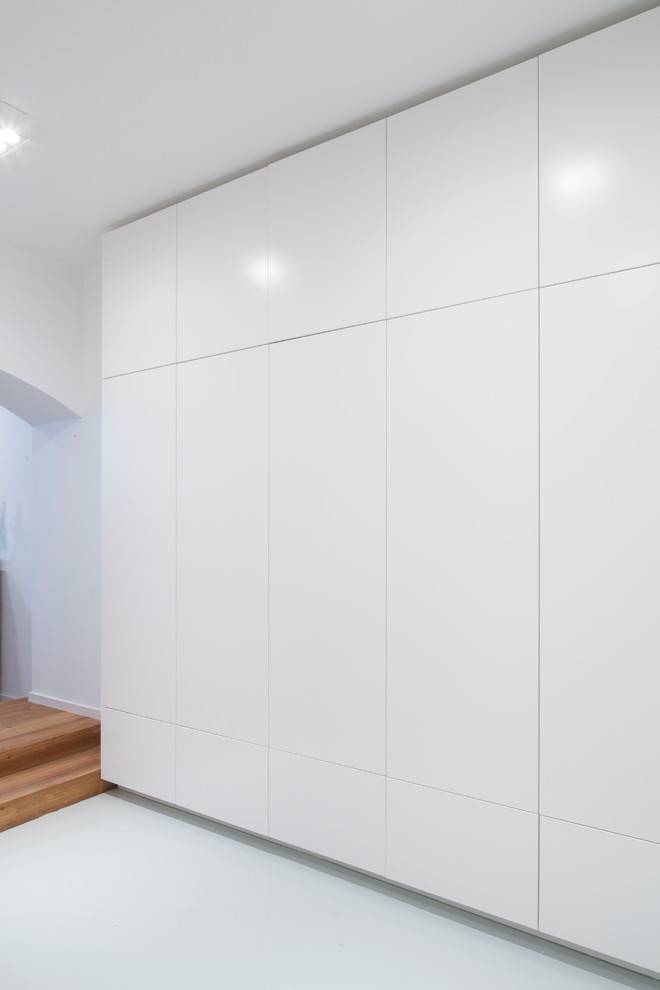 Cette photo montre un couloir moderne de taille moyenne avec un mur blanc, parquet clair et un sol marron.
