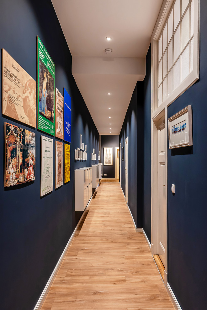 Inspiration for a large timeless light wood floor and beige floor hallway remodel in Berlin with blue walls