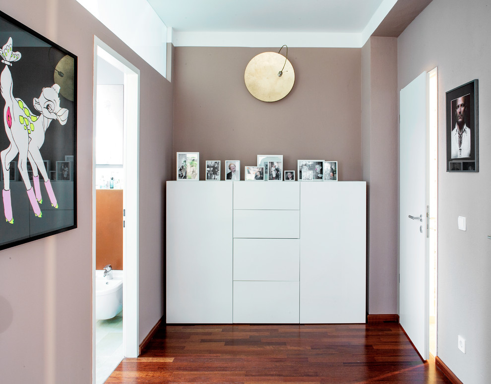 Inspiration pour un couloir design de taille moyenne avec un mur violet et un sol en bois brun.