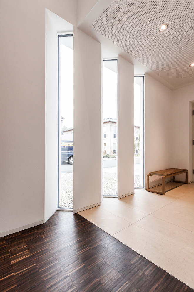 Идея дизайна: узкий коридор в современном стиле с белыми стенами и темным паркетным полом