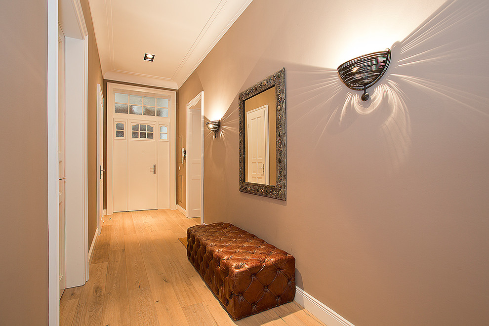 Example of a mid-sized transitional light wood floor hallway design in Other with gray walls