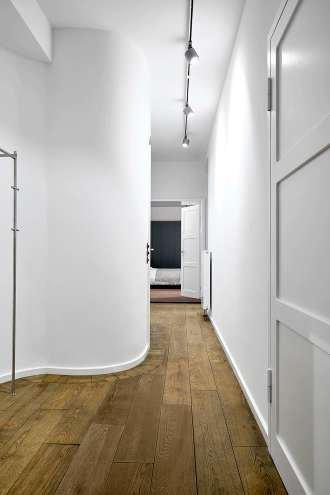 Свежая идея для дизайна: коридор среднего размера в стиле модернизм с белыми стенами, темным паркетным полом и коричневым полом - отличное фото интерьера
