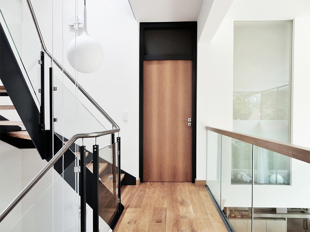 Immagine di un ingresso o corridoio minimal di medie dimensioni con pareti bianche e pavimento in legno massello medio