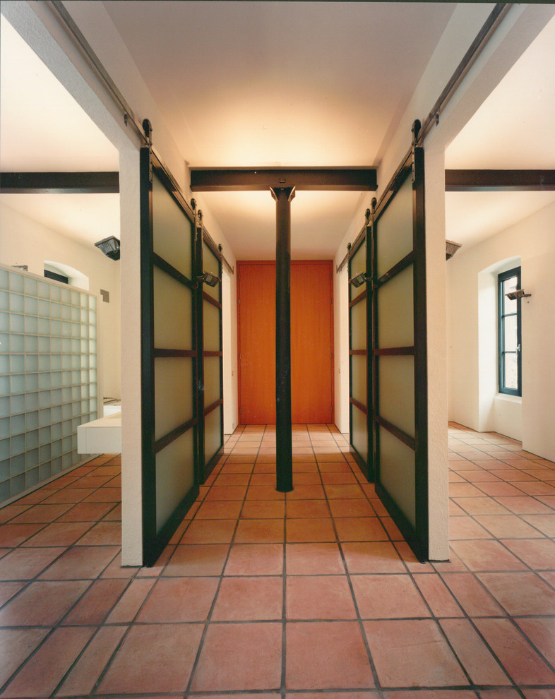 Diseño de recibidores y pasillos actuales con paredes blancas y suelo de baldosas de terracota