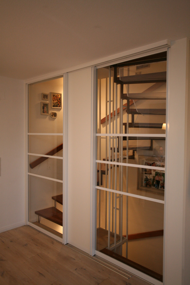 Idee per un ingresso o corridoio minimalista di medie dimensioni con pareti bianche, pavimento in legno massello medio e pavimento marrone