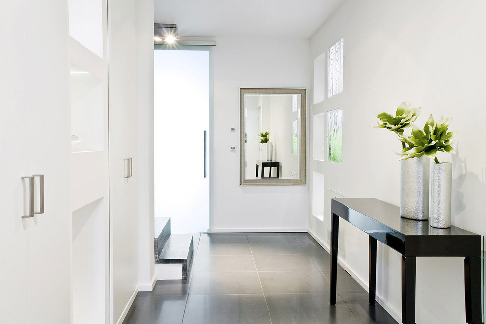 Exemple d'un couloir tendance de taille moyenne avec un mur blanc, sol en béton ciré et un sol gris.