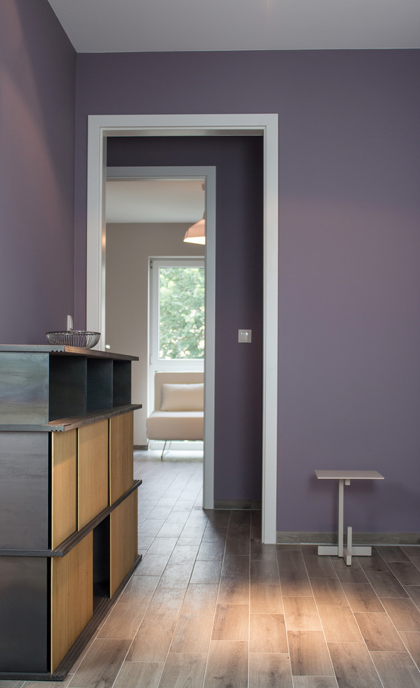 Idées déco pour un petit couloir éclectique avec un mur violet, un sol en carrelage de céramique et un sol marron.