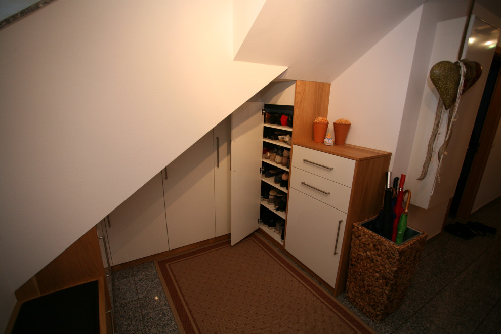 Cette image montre un couloir minimaliste de taille moyenne avec un mur blanc, un sol en marbre et un sol gris.