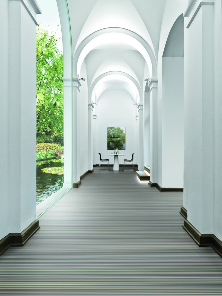 Aménagement d'un grand couloir contemporain avec un mur blanc et un sol en vinyl.