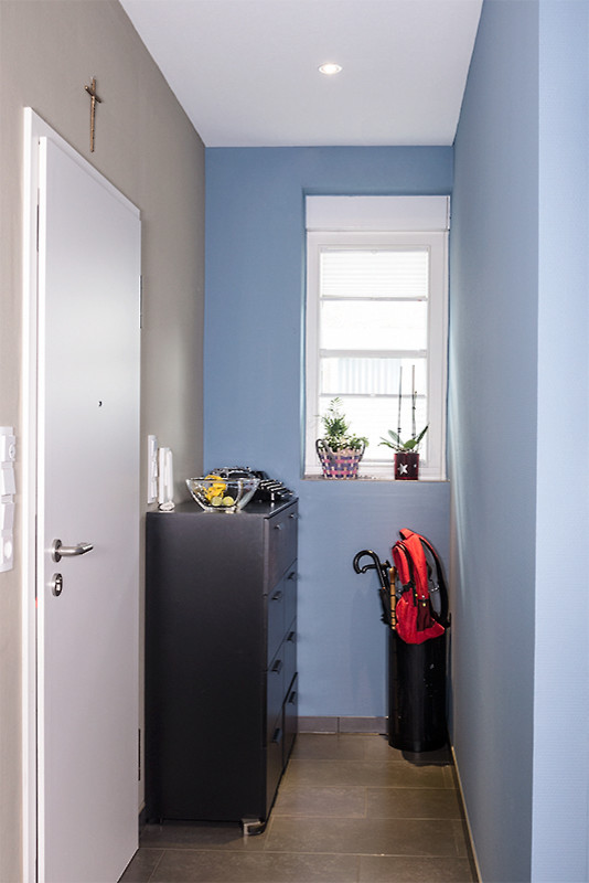 Inspiration för en liten funkis hall, med blå väggar, klinkergolv i keramik och brunt golv