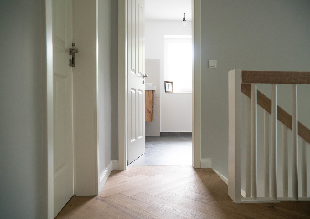 Пример оригинального дизайна: большой коридор в стиле кантри с серыми стенами, паркетным полом среднего тона и разноцветным полом