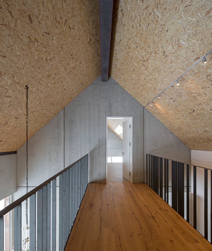 Idee per un ingresso o corridoio industriale di medie dimensioni con pareti grigie, pavimento in legno massello medio e pavimento marrone
