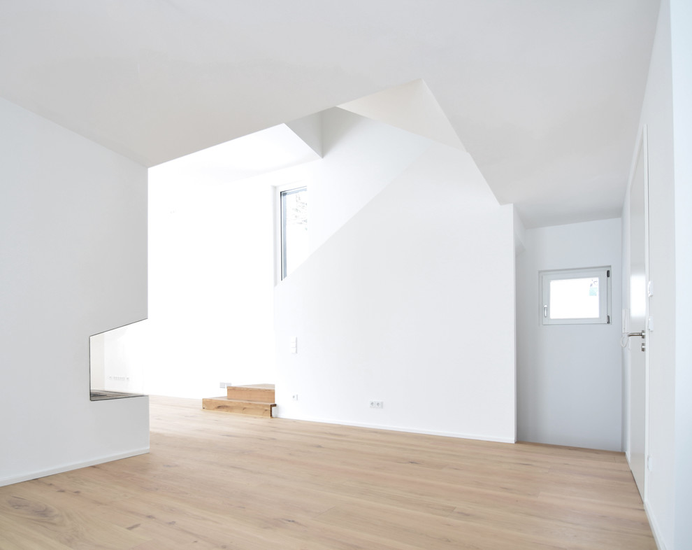 Idée de décoration pour un grand couloir design avec un mur blanc et parquet clair.