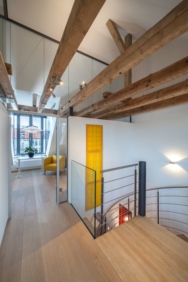 Example of a trendy light wood floor and brown floor hallway design in Munich with white walls