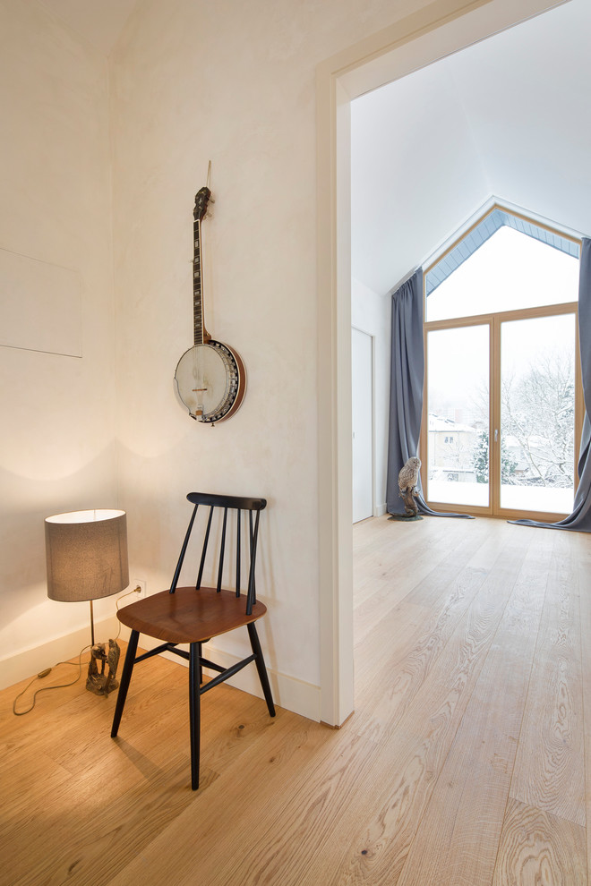 Idéer för en mellanstor minimalistisk hall, med svarta väggar, mellanmörkt trägolv och brunt golv
