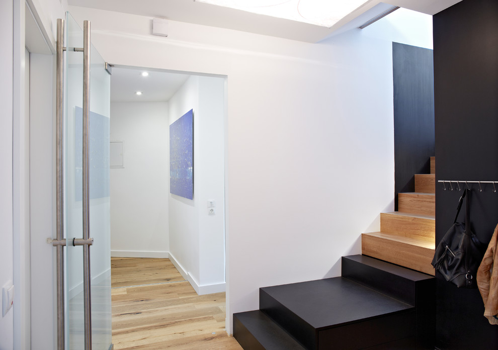 Hallway - mid-sized contemporary medium tone wood floor hallway idea in Munich with white walls