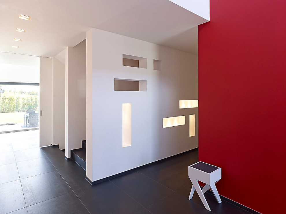 Cette image montre un couloir design de taille moyenne avec un mur rouge.