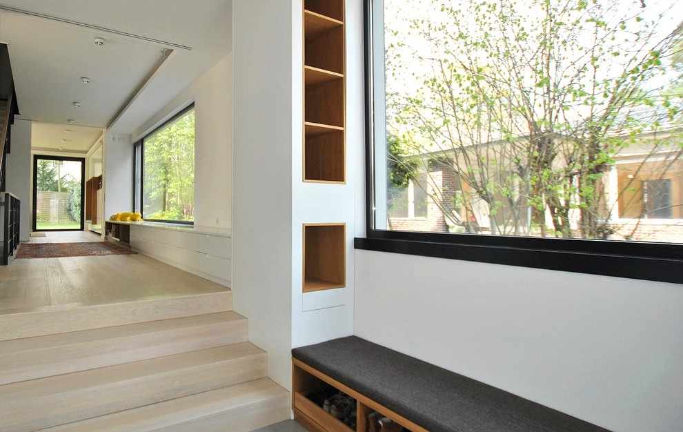 Inspiration pour un couloir minimaliste de taille moyenne avec un mur blanc, parquet clair et un sol beige.