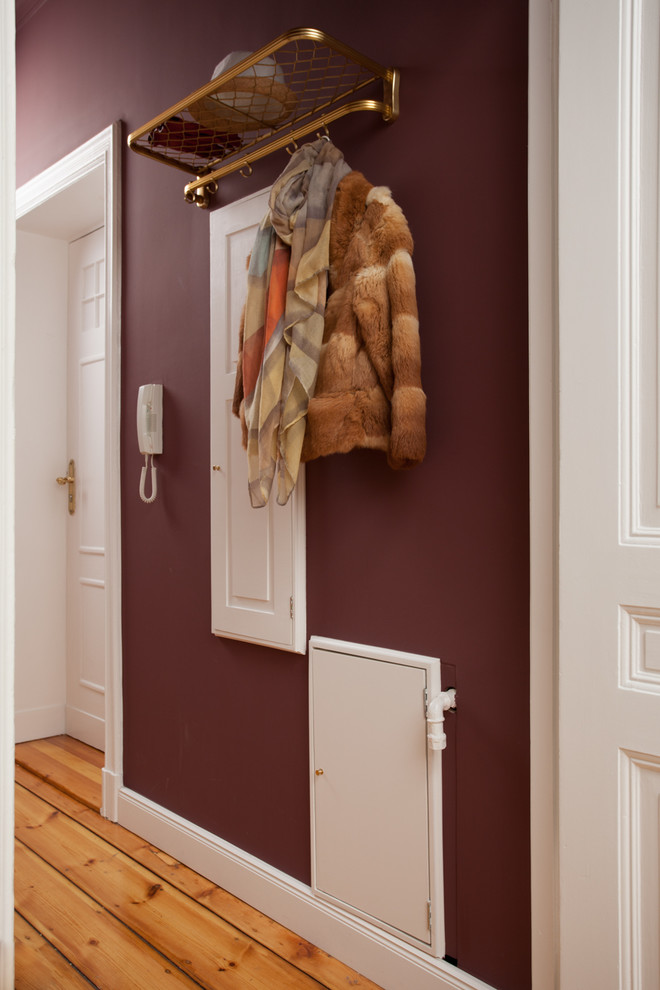 Cette image montre un petit couloir traditionnel avec un mur violet, parquet clair et un sol beige.