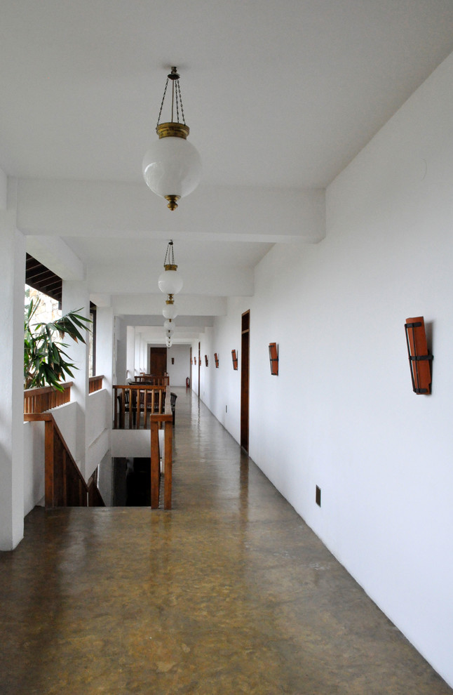 Idéer för att renovera en mycket stor tropisk hall, med vita väggar, betonggolv och grått golv