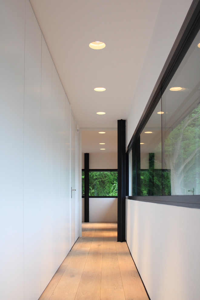 Пример оригинального дизайна: коридор среднего размера: освещение в стиле лофт с белыми стенами, светлым паркетным полом и бежевым полом