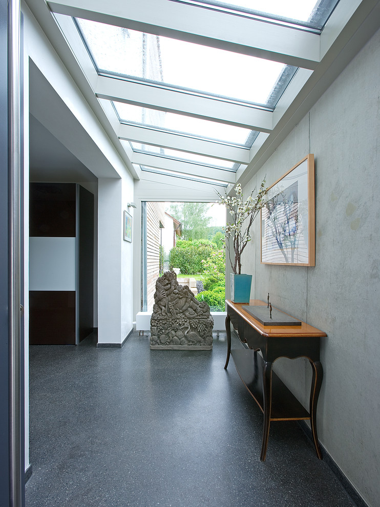 Idée de décoration pour un couloir design avec un mur gris.