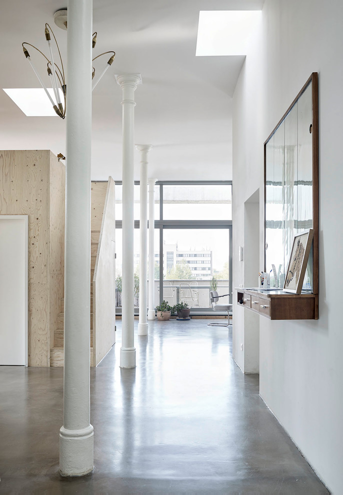 Immagine di un grande ingresso o corridoio minimal con pareti bianche e pavimento grigio