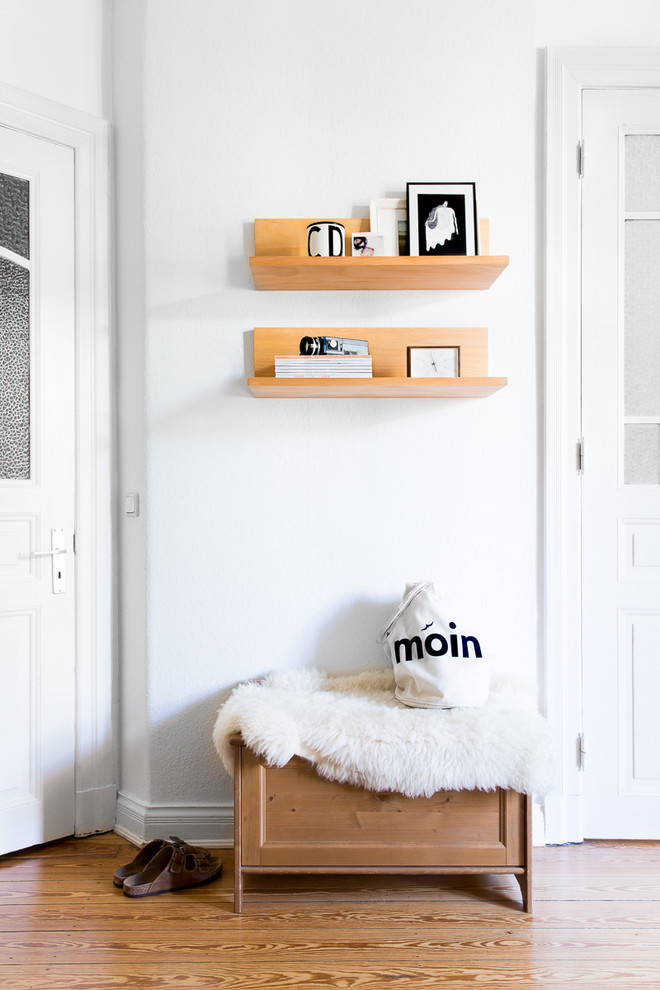 Idées déco pour un petit couloir scandinave avec un mur blanc et un sol en bois brun.