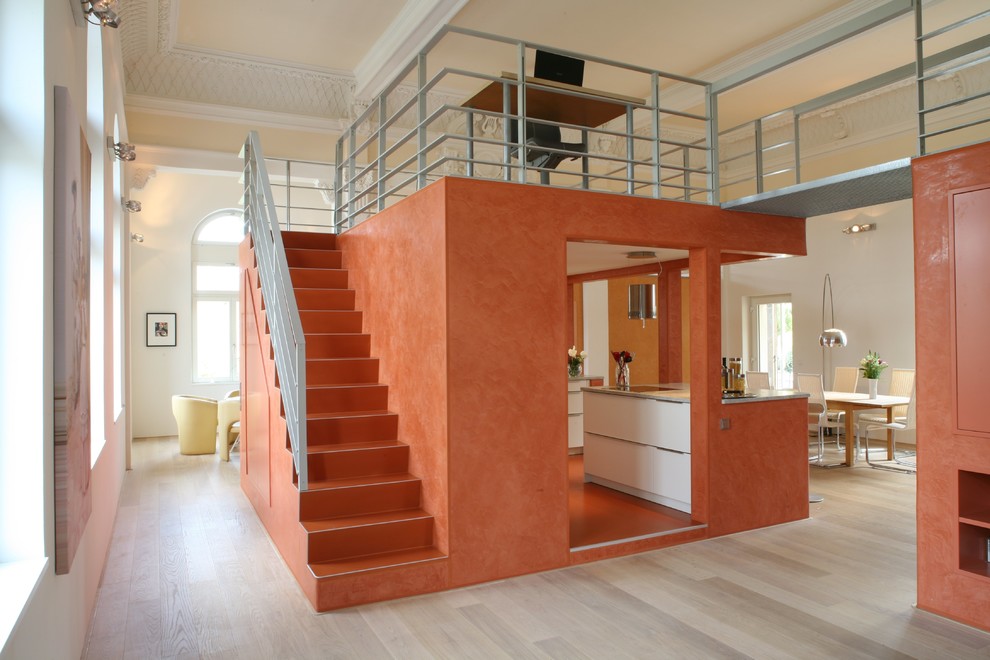 Exempel på en liten modern hall, med orange väggar och ljust trägolv