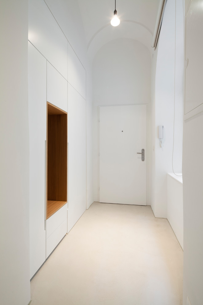 Ispirazione per un ingresso o corridoio moderno di medie dimensioni con pareti bianche, pavimento in cemento e pavimento beige