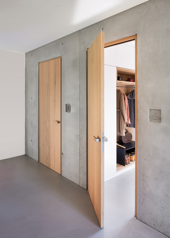 Idee per un ampio ingresso o corridoio scandinavo con pareti grigie, pavimento in cemento e pavimento grigio