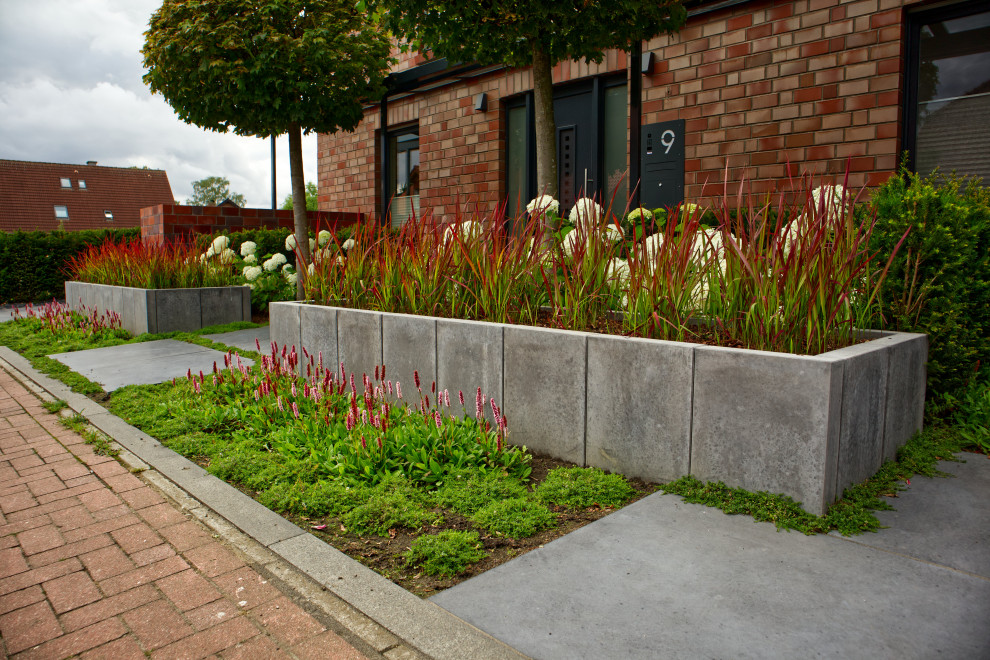 Пример оригинального дизайна: регулярный сад среднего размера на переднем дворе в современном стиле с высокими грядками и мощением тротуарной плиткой