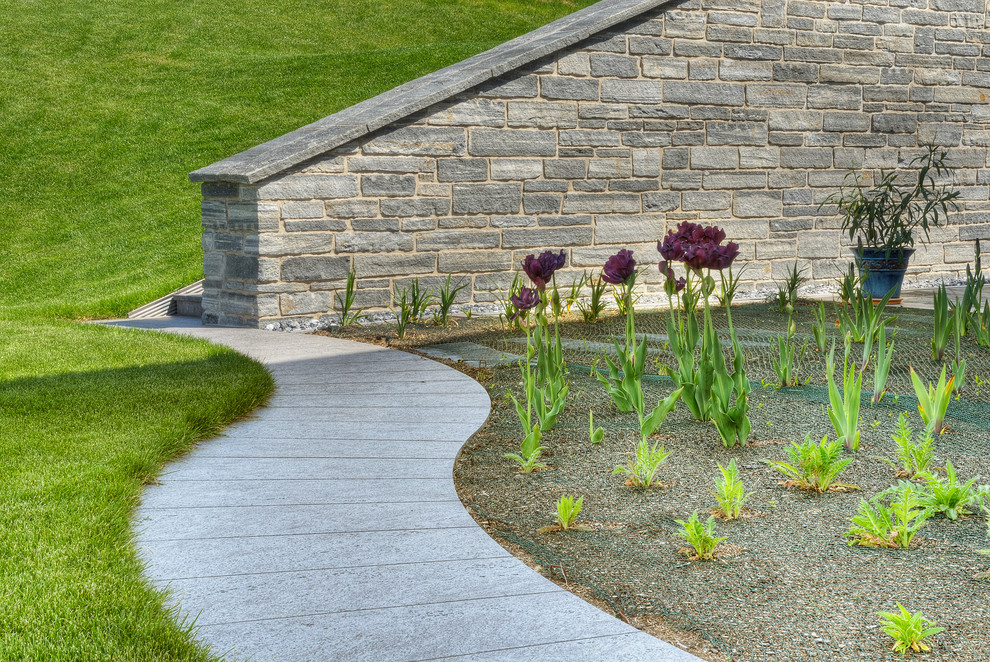 Klassischer Gartenweg hinter dem Haus mit Natursteinplatten in Sonstige