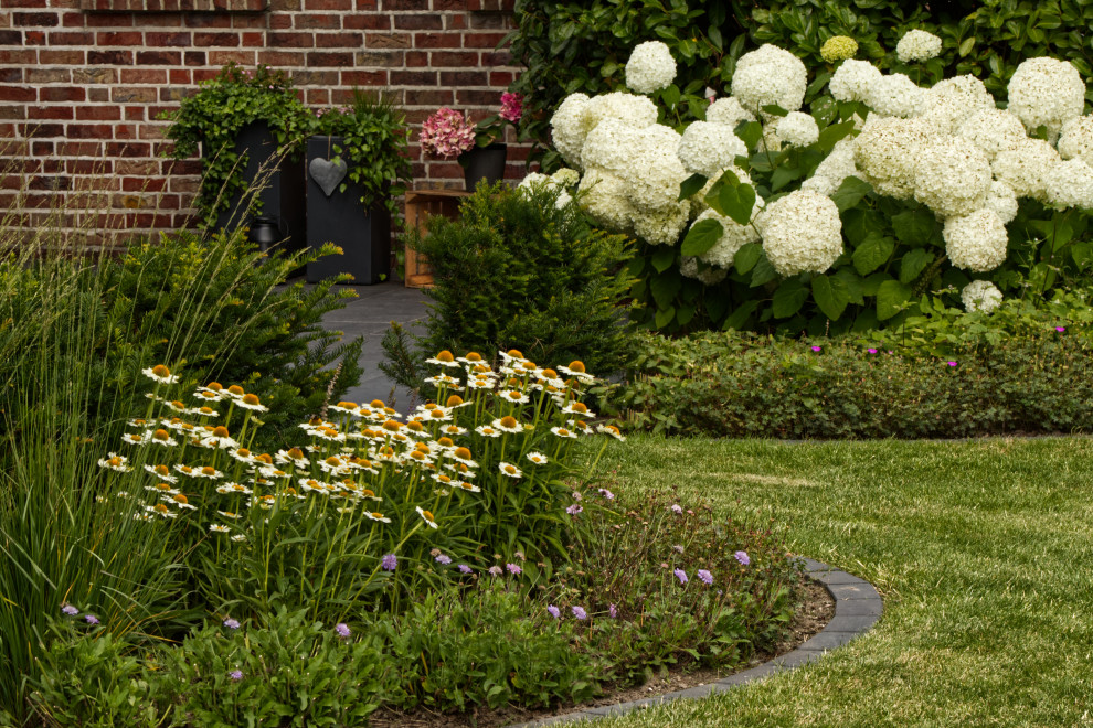 Exemple d'un jardin romantique de taille moyenne et l'été avec un massif de fleurs et une exposition ensoleillée.