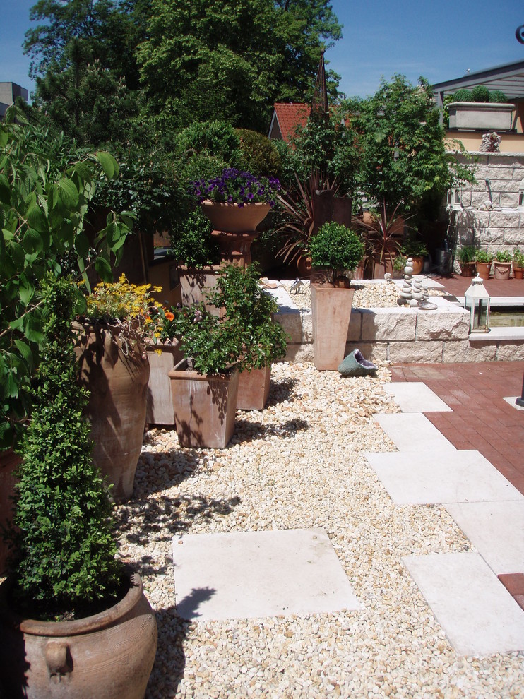 Cette photo montre un petit jardin méditerranéen l'été avec une exposition ensoleillée et des pavés en béton.