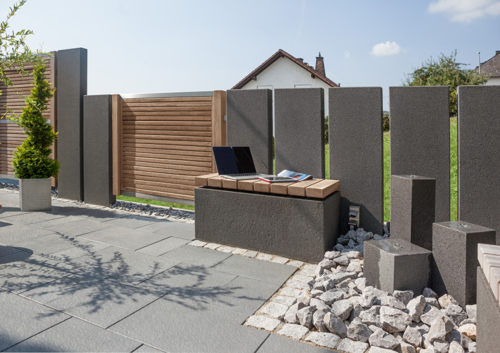 Idee per un privacy in giardino chic dietro casa con pavimentazioni in cemento