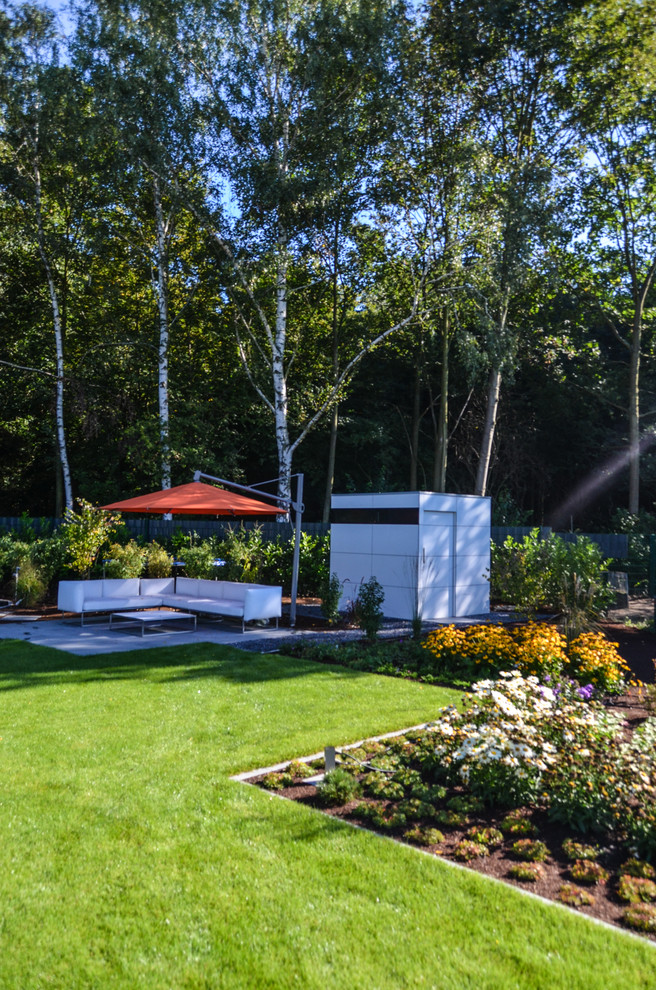 Modelo de jardín actual en verano en patio lateral con exposición parcial al sol y jardín francés
