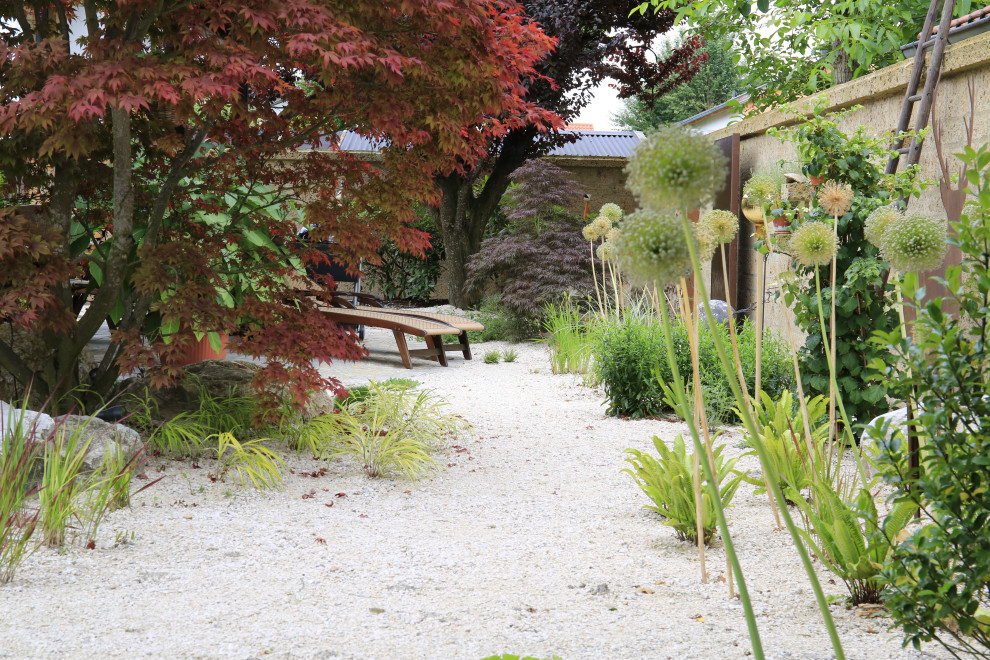 Ejemplo de jardín de estilo zen grande en patio con macetero elevado, exposición parcial al sol y adoquines de piedra natural