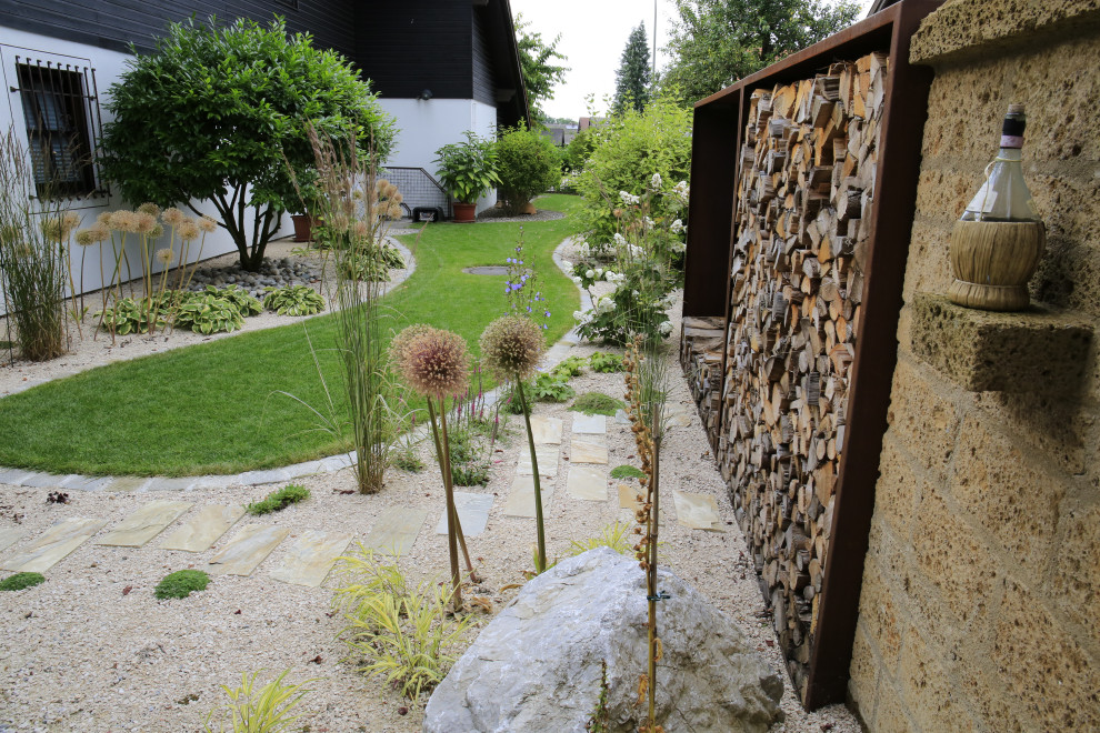Großer, Halbschattiger Asiatischer Garten im Innenhof mit Hochbeet und Natursteinplatten in München