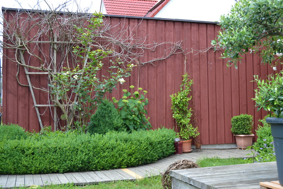 Foto di un ampio giardino formale country esposto a mezz'ombra davanti casa in primavera con un ingresso o sentiero e pedane
