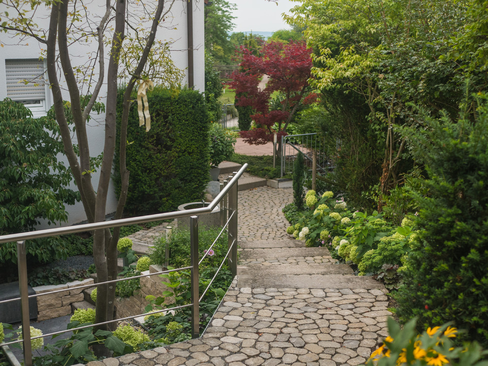Inspiration for a mid-sized contemporary front yard stone landscaping in Stuttgart.