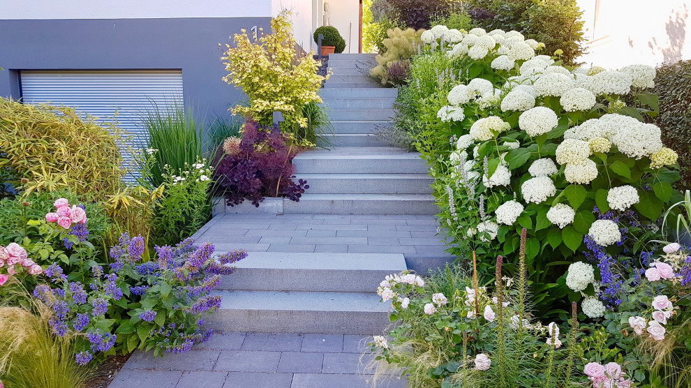 Immagine di un giardino design esposto a mezz'ombra di medie dimensioni in estate con un pendio, una collina o una riva e pavimentazioni in cemento