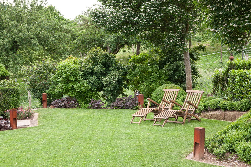 Ejemplo de jardín de estilo de casa de campo de tamaño medio en verano en patio lateral con exposición total al sol