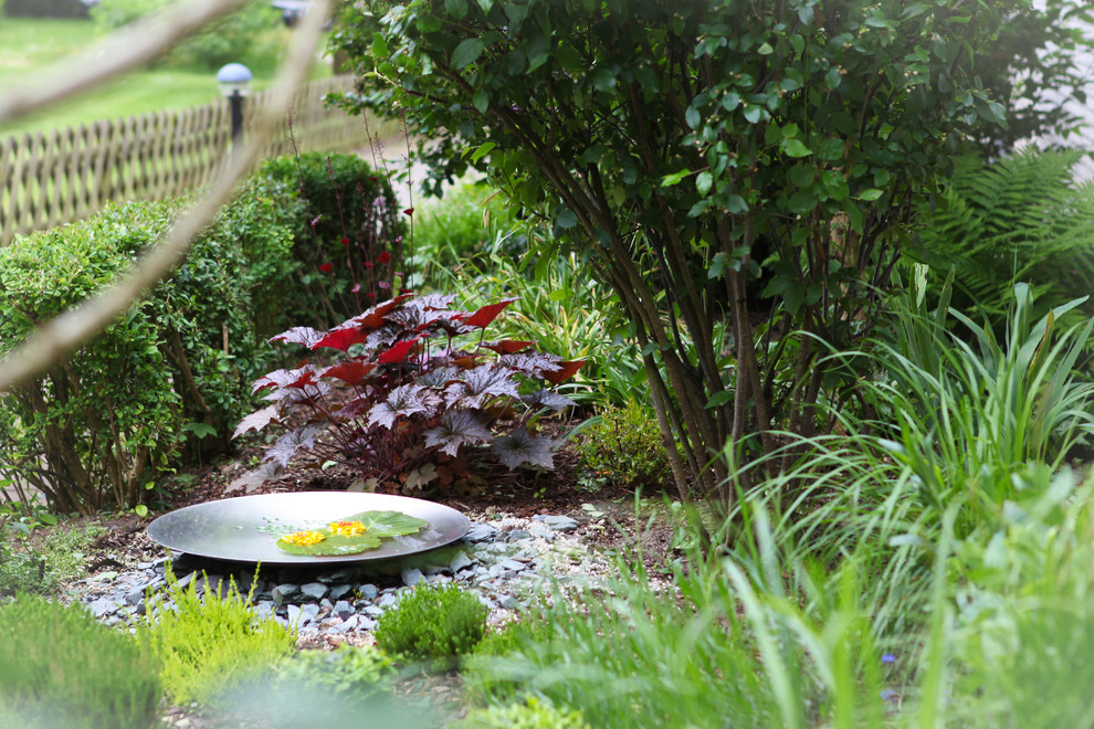 Idéer för en klassisk trädgård i delvis sol framför huset på sommaren, med en fontän och grus
