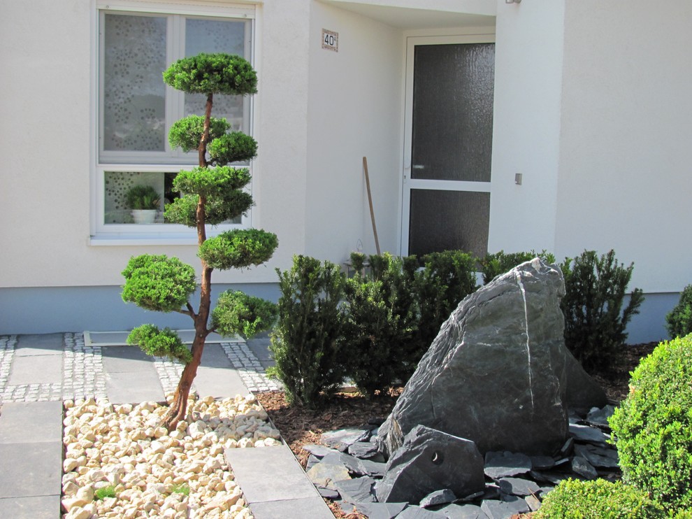 Kleiner, Halbschattiger Moderner Vorgarten im Sommer mit Natursteinplatten und Gehweg in Sonstige