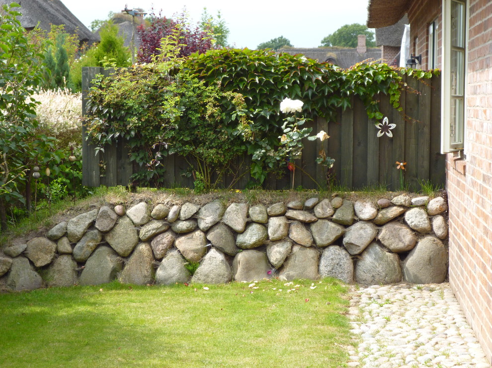 Nordische Gartenmauer mit Natursteinplatten in Sonstige