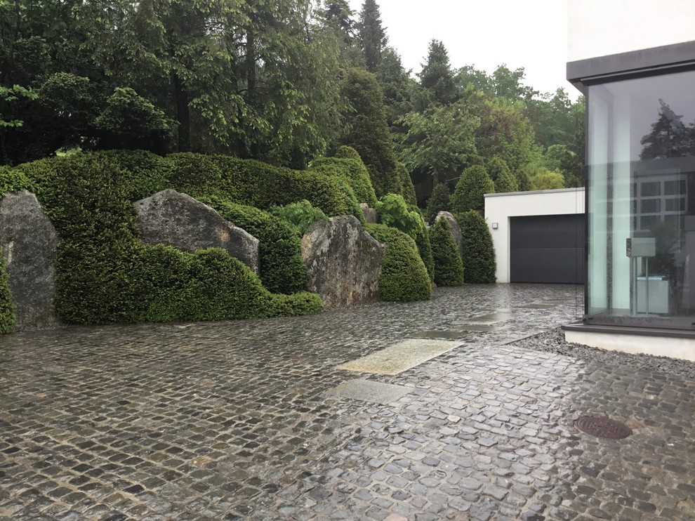 Medium sized world-inspired driveway garden in Nuremberg with a garden path and natural stone paving.